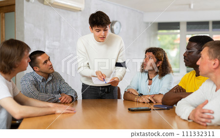 Group of men discussing something at the desk 111332311
