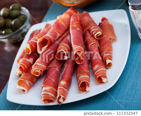 Rolled up slices of dry-cured ham 111332347