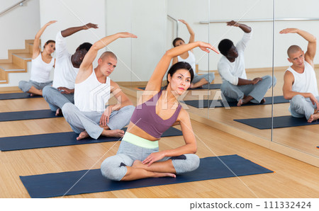 Multiethnic group of young people practicing yoga Multiethnic group of young people practicing yoga 111332424