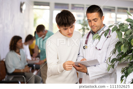 Doctor consults a man at the clinic 111332625