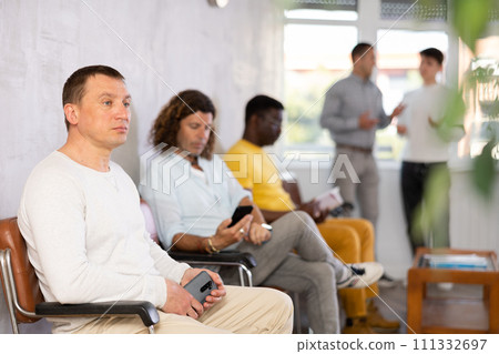 Portrait of a focused European man sitting waiting Portrait of a focused European man sitting waiting 111332697