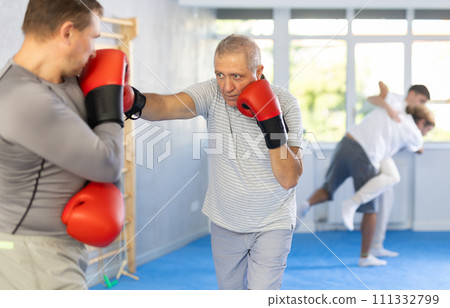 Two men training boxing fight in studio Two men training boxing fight in studio 111332799