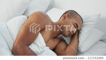Man, resting and sleeping in bed at home, peace and dreaming or relax on sunday morning. Male person, comfortable and blanket for stress relief, lazy and house nap on soft bedding and calm on weekend 111332800