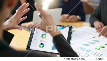 People, meeting and tablet screen of data analytics, graphs and statistics in finance, business or revenue proposal. Professional employees, analyst or manager talking of digital sales and documents People, meeting and tablet screen of data analytics, graphs and statistics in finance, business or revenue proposal. Professional employees, analyst or manager talking of digital sales and documents 111332803