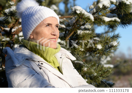 Happy old woman in a fur coat in the winter.  111333178