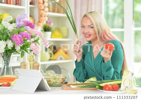 Young woman cooking healthy food in kitchen Young woman cooking healthy food in kitchen 111333207