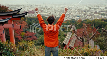 Man, fist celebration and mountain with view, city and torii gates at Fushimi Inari shrine for shinto religion. Person, hiking and cheers by trees, pillar or achievement on spiritual journey in Kyoto Man, fist celebration and mountain with view, city and torii gates at Fushimi Inari shrine for shinto religion. Person, hiking and cheers by trees, pillar or achievement on spiritual journey in Kyoto 111333321