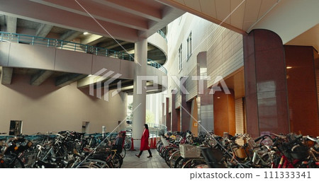 City, walking and woman in building with bicycle for travelling, commute and bike parking or station. Transport, urban town and Japanese person with storage for sustainable vehicles for journey City, walking and woman in building with bicycle for travelling, commute and bike parking or station. Transport, urban town and Japanese person with storage for sustainable vehicles for journey 111333341