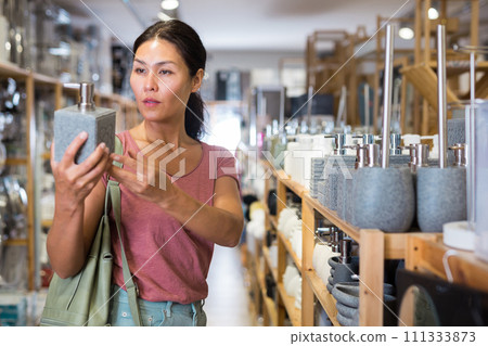 Woman choosing soap dispencer 111333873