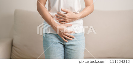 woman having abdomen ache due to Stomach pain, digestion with constipation or Diarrhea from food poisoning, female problem and Endometriosis, Hysterectomy and Menstrual on the sofa at home 111334213