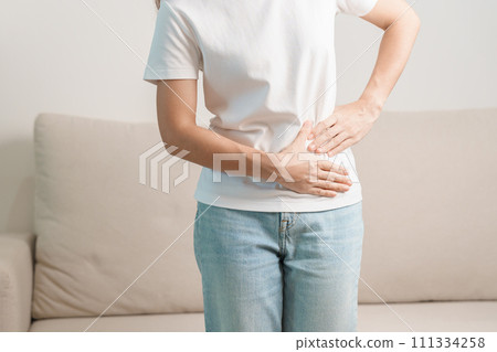 Woman having abdomen pain on the sofa at home. Liver cancer and Tumor, kidney cancer, Jaundice, Viral Hepatitis, Cirrhosis, Failure, Enlarged, Hepatic Encephalopathy, Stomach and health concept Woman having abdomen pain on the sofa at home. Liver cancer and Tumor, kidney cancer, Jaundice, Viral Hepatitis, Cirrhosis, Failure, Enlarged, Hepatic Encephalopathy, Stomach and health concept 111334258