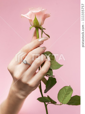 Beautiful woman's nails with  pearl manicure and rose on pink background Beautiful woman's nails with  pearl manicure and rose on pink background 111335757