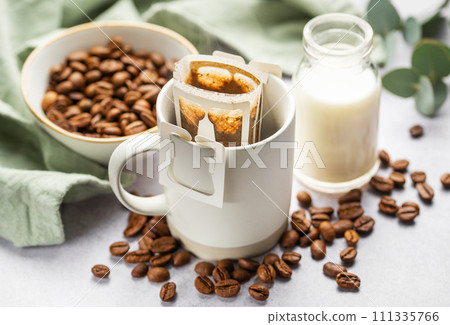 Drip coffee bag with ground coffee in cup Drip coffee bag with ground coffee in cup 111335766