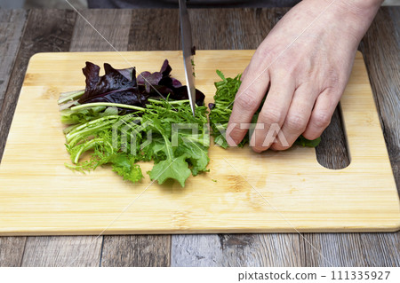 Muskran salad, vegetables, vegan salad, cut with a knife 111335927