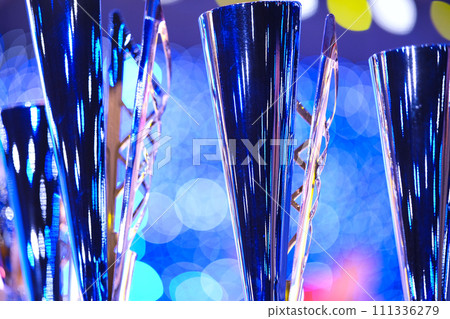 Close-up of golden trophies lined up at a dance event. Collection of trophies. Award cups close up Close-up of golden trophies lined up at a dance event. Collection of trophies. Award cups close up 111336279
