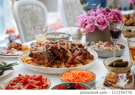 Delicious Uzbek Lamb Pilaf with Fragrant Rice, Tender Meat, Fresh Salads, and Pickles 111336776