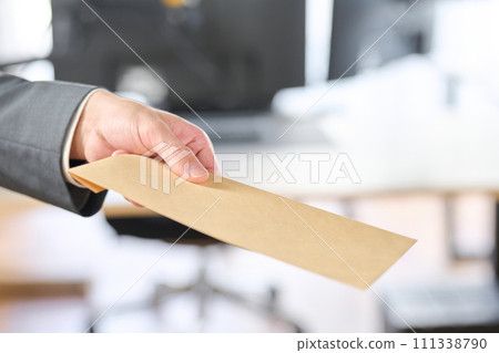 Businessman holding out an envelope Businessman holding out an envelope 111338790