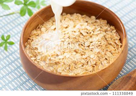 Pour milk into oatmeal 111338849