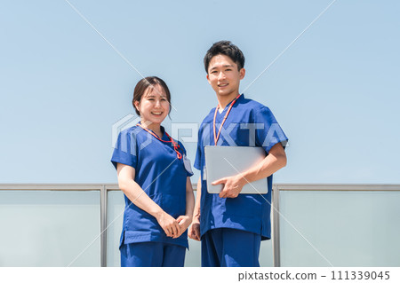 Men and women of doctors, doctors, nurses, medical workers, doctors, occupational therapists, and physical therapists talking on the roof of the hospital 111339045