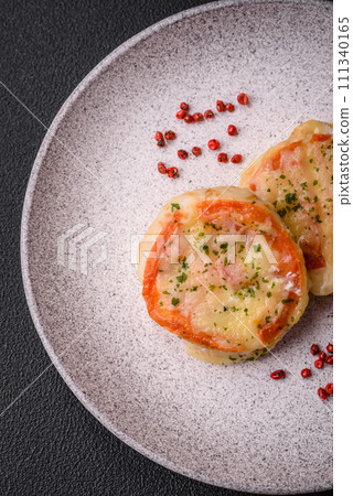 Delicious baked fish fillet with cheese, tomatoes, salt, spices and herbs Delicious baked fish fillet with cheese, tomatoes, salt, spices and herbs 111340165