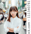 A girl in a white shirt standing in a crowd 111340781