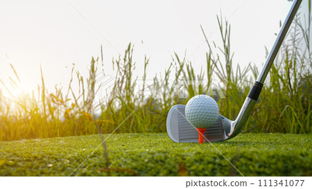 Golf club and ball in green grass. Golf balls on the golf course with golf clubs ready for golf in the first short. Golf club and ball in green grass. Golf balls on the golf course with golf clubs ready for golf in the first short. 111341077
