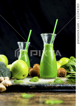 Healthy green smoothies with spinach, apple, kiwi, broccoli and mint in glass jar with fruits and vegetables on the wooden table. Detox and healthy concept 111341363