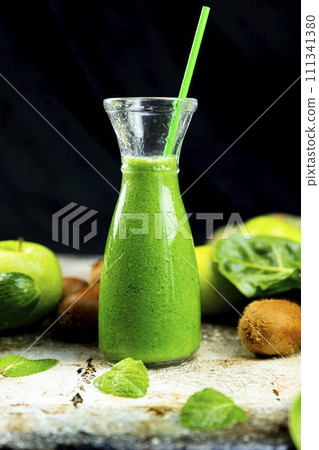 Healthy green smoothies with spinach, apple, kiwi, broccoli and mint in glass jar with fruits and vegetables on the wooden table. Detox and healthy concept 111341380