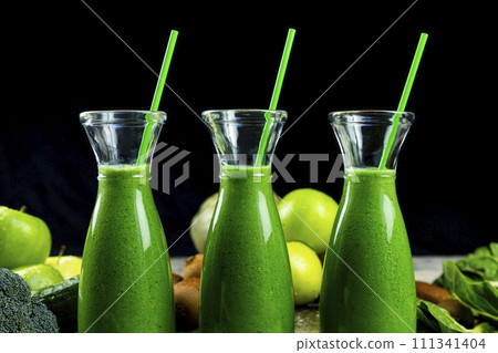 Healthy green smoothies with spinach, apple, kiwi, broccoli and mint in glass jar with fruits and vegetables on the wooden table. Detox and healthy concept 111341404