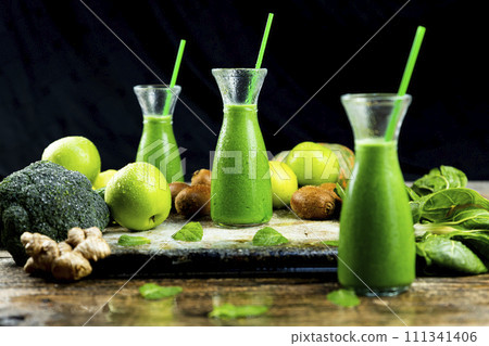 Healthy green smoothies with spinach, apple, kiwi, broccoli and mint in glass jar with fruits and vegetables on the wooden table. Detox and healthy concept 111341406