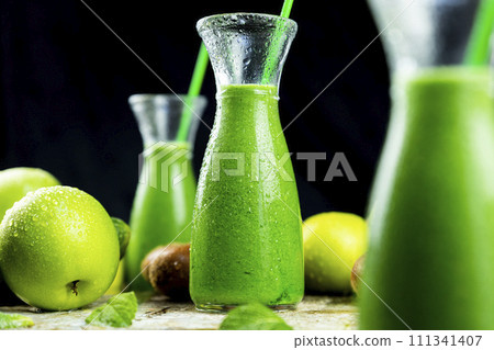 Healthy green smoothies with spinach, apple, kiwi, broccoli and mint in glass jar with fruits and vegetables on the wooden table. Detox and healthy concept 111341407
