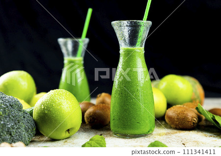 Healthy green smoothies with spinach, apple, kiwi, broccoli and mint in glass jar with fruits and vegetables on the wooden table. Detox and healthy concept 111341411