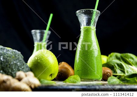 Healthy green smoothies with spinach, apple, kiwi, broccoli and mint in glass jar with fruits and vegetables on the wooden table. Detox and healthy concept 111341412