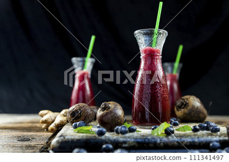 Juice with Beetroot, blueberries and mint in glass jar with fruits and vegetables on the wooden table. Detox, diet, healthy, vegetarian drink concept 111341497