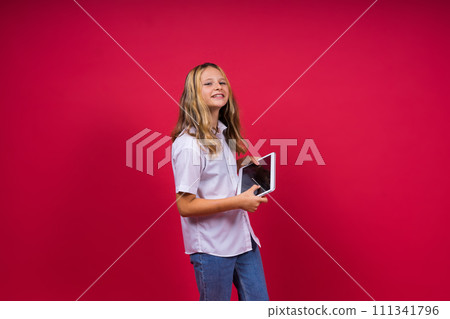 Online school app. Schoolgirl showing tablet computer Empty Screen Over red Background. Studio Shot Online school app. Schoolgirl showing tablet computer Empty Screen Over red Background. Studio Shot 111341796