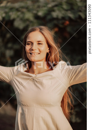 Woman stands in front of vineyard. She is wearing a light dress and posing for a photo. Travel concept to different countries 111343090