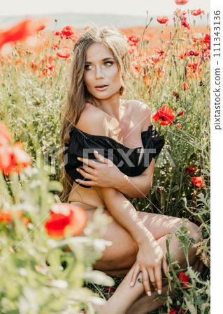 Woman poppies field. portrait happy woman with long hair in a poppy field and enjoying the beauty of nature in a warm summer day. 111343136