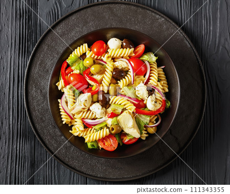 fusilli salad with mozzarella, veggies in a bowl fusilli salad with mozzarella, veggies in a bowl 111343355