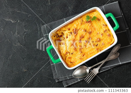 cheesy smoked sausage grits bake in ceramic dish 111343363