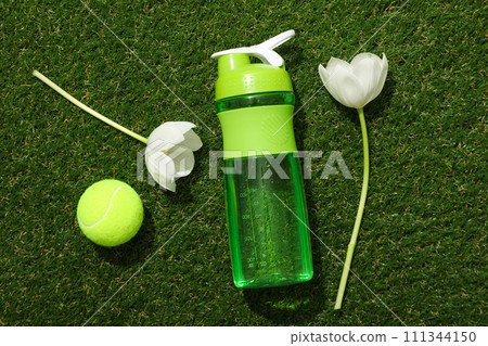 Green bottle for water, with flowers on a green background. 111344150