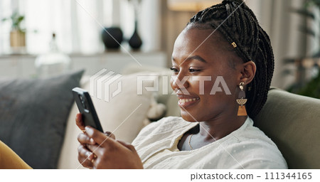Funny, smile and black woman on a couch, cellphone or connection with social media, comedy post or laugh. African person, apartment or girl on sofa, smartphone or mobile user with humor, home or joke Funny, smile and black woman on a couch, cellphone or connection with social media, comedy post or laugh. African person, apartment or girl on sofa, smartphone or mobile user with humor, home or joke 111344165
