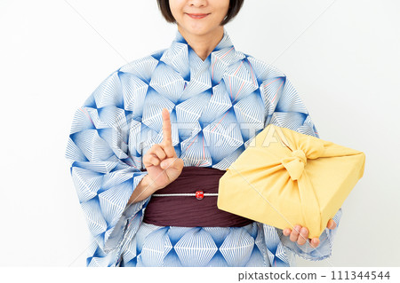 身穿浴衣、手拿年中禮物包布、舉起食指的中年婦女 身穿浴衣、手拿年中禮物包布、舉起食指的中年婦女 111344544