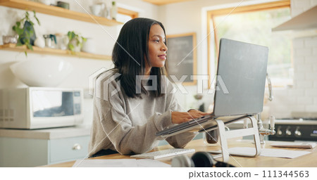 Laptop, documents and remote work with a woman entrepreneur in the kitchen of her home for small business. Computer, report and a young female freelance employee working on a startup from her house 111344563