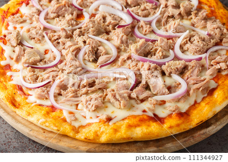 Mediterranean traditional Pizza Tuna with tomato sauce, canned tuna, mozzarella cheese and red onion close-up on a wooden board. Horizontal 111344927