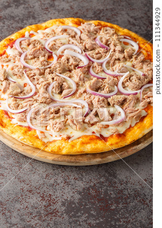 Pizza tonno e cipolla topped with tomato sauce, mozzarella, tuna, and sliced onions closeup on the wooden board. Vertical Pizza tonno e cipolla topped with tomato sauce, mozzarella, tuna, and sliced onions closeup on the wooden board. Vertical 111344929