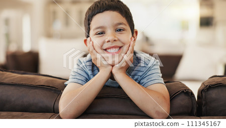 Happy, cute and face of a child on the sofa for playing, relax and weekend fun. Smile, youth and portrait of a little boy kid with an adorable expression, charming and on vacation on the couch 111345167