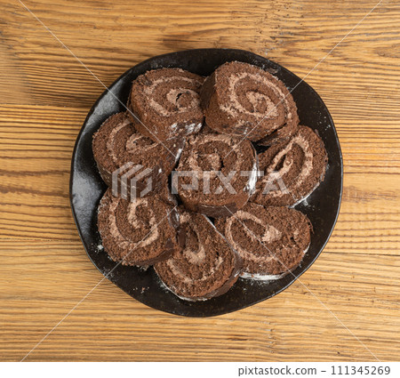 Chocolate Swiss Roll, Round Sponge Cake, Sliced Rolled Vanilla Biscuit with Cocoa Cream Filling Chocolate Swiss Roll, Round Sponge Cake, Sliced Rolled Vanilla Biscuit with Cocoa Cream Filling 111345269