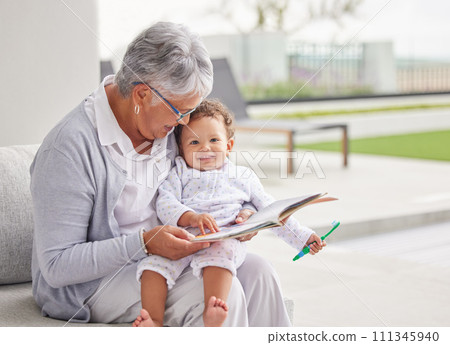 Senior woman, happy baby and children book reading of a grandmother spending quality time together. Elderly retirement of a old female about to read a fun kids story to a kid on a home patio Senior woman, happy baby and children book reading of a grandmother spending quality time together. Elderly retirement of a old female about to read a fun kids story to a kid on a home patio 111345940