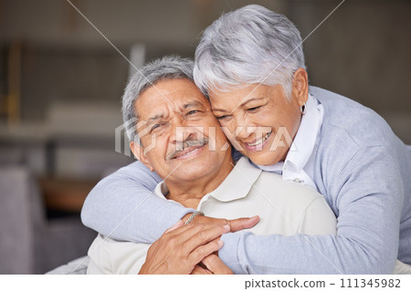 Living room, love and senior couple hug on sofa for romantic embrace while they relax together in home. Care, trust and happiness in married relationship with partner in sweet marriage and commitment 111345982