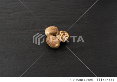Nutmeg in Black Plate, Myristica Fragrans Fruit, Dry Spicy Nutmeg, Grated Whole Muscat Nut, Nut Meg 111346334